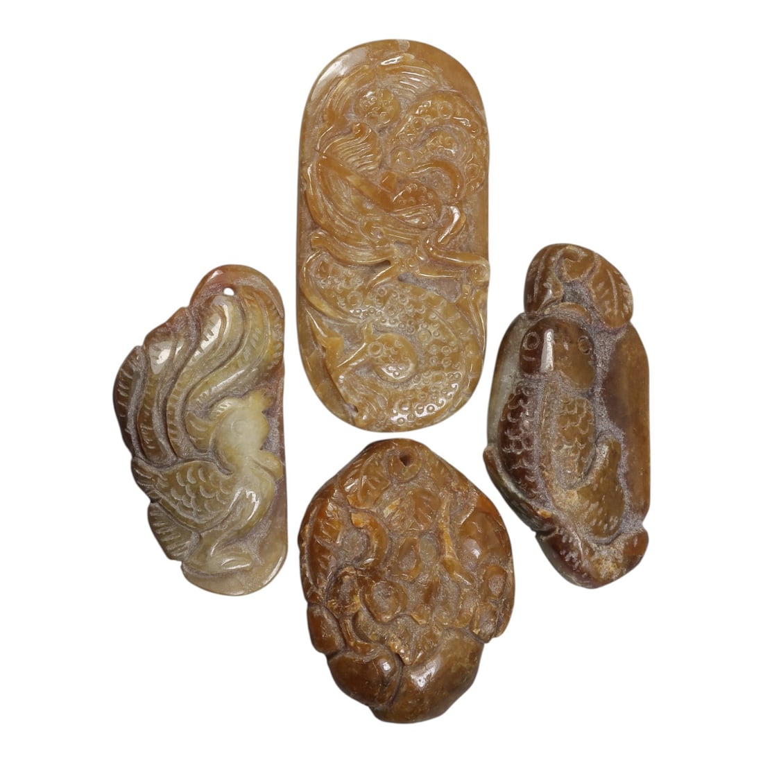 Lot of 4 Antique Oriental Chinese Jade Carved Pendants, 31AG: Carved from yellowish-brown jade with natural color variations, inclusions, and surface patina, the group consists of four pendants with varied relief motifs. One pendant depicts a phoenix with incise