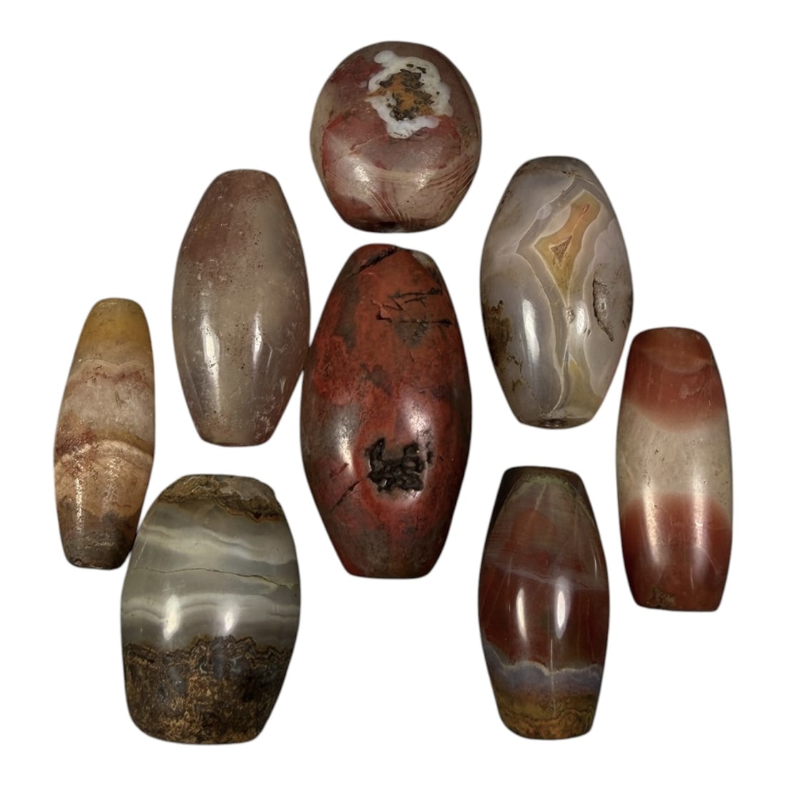 Lot of 8 Himalayan Banded Agate Beads, Ancient to Antique Period, 99AG: A group of eight beads crafted from banded agate, displaying natural variations in tone including translucent grey, reddish-brown, yellow, cream, and multi-tonal banding patterns. The forms are primar