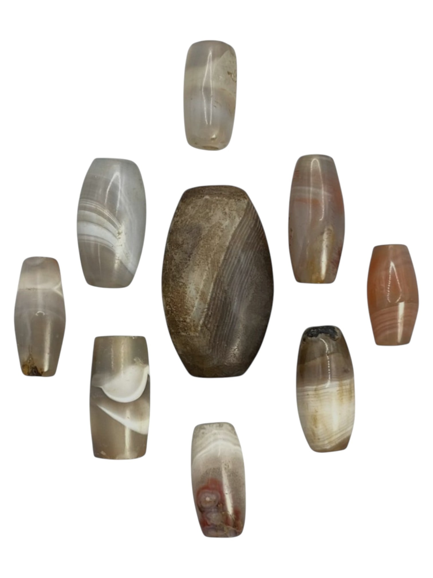 Lot of 9 Himalayan Banded Agate Beads, Ancient to Antique Period, 49WT: A group of nine beads crafted from banded agate, showcasing a spectrum of natural tones including translucent grey, pale brown, white, and subtle reddish hues, with characteristic concentric, wavy, an