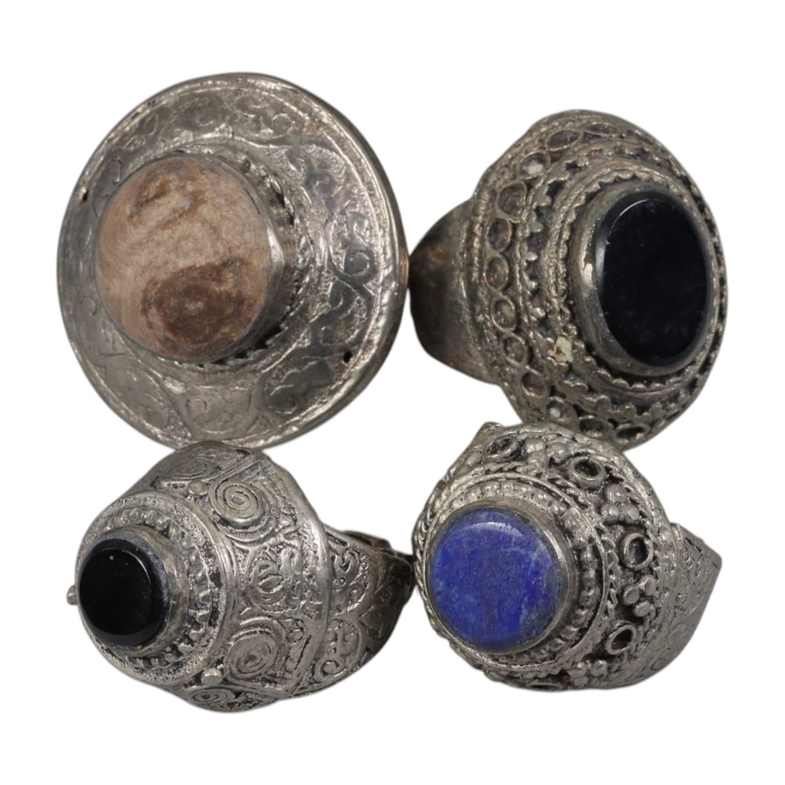 Lot of 4 Vintage Central Asian Tribal Silver-Plated Statement Rings, 70AH: A set of four vintage statement rings, crafted in silver-plated metal with intricate tribal-style ornamentation characteristic of Central Asian or Himalayan jewelry traditions. Each ring features dist
