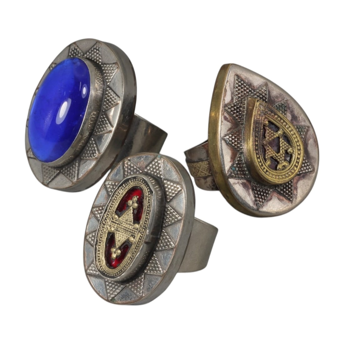 Lot of 3 Vintage North African (Berber / Tuareg) Silver-Plated Gilt Statement Rings, 56AH: A set of three vintage statement rings, crafted in silver-plated metal with gilt accents, featuring traditional North African Berber or Tuareg-inspired designs. The rings display signature motifs of t