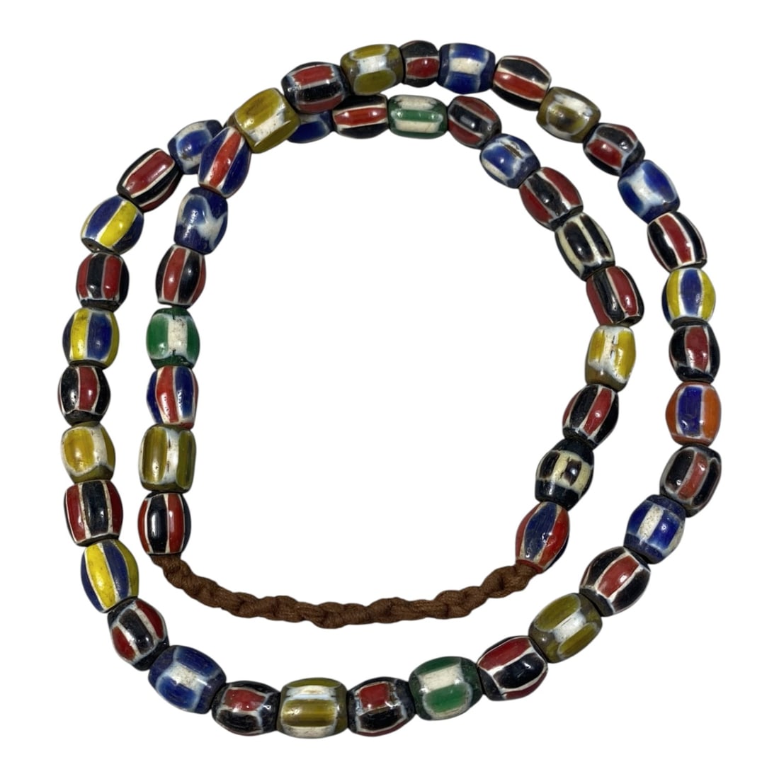 Strand of Antique Chevron Glass Beads, Unstrung, 43AH: A single strand of unstrung antique chevron glass beads, measuring approximately 29 cm in length. The strand features barrel-shaped beads adorned with vibrant, multicolored striped chevron patterns, c