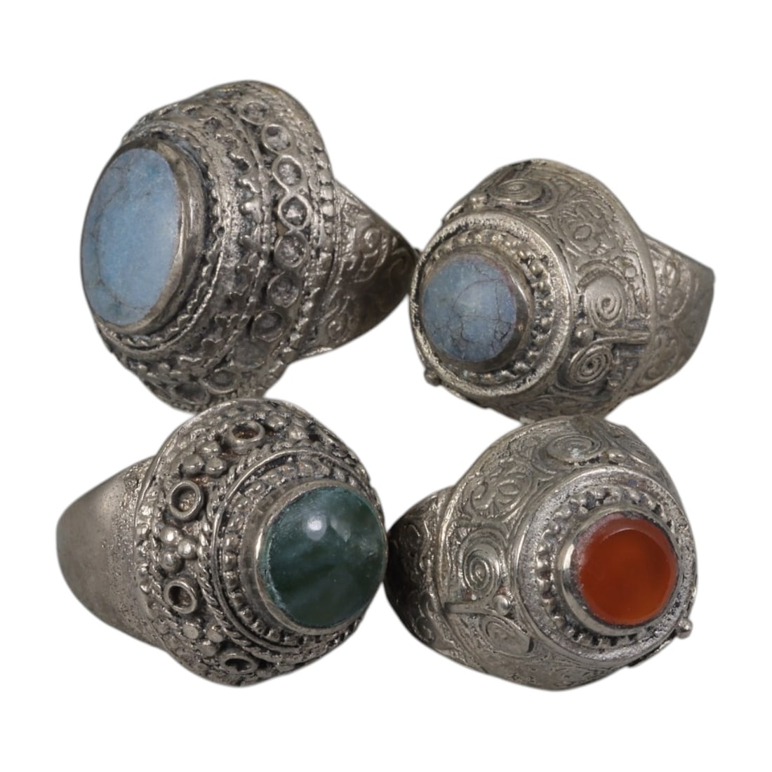 Lot of 4 Vintage Central Asian Tribal Silver-Plated Statement Rings, 69AH: A set of four vintage statement rings, crafted in silver-plated metal with intricate tribal-style ornamentation characteristic of Central Asian or Himalayan jewelry traditions. Each ring features dist