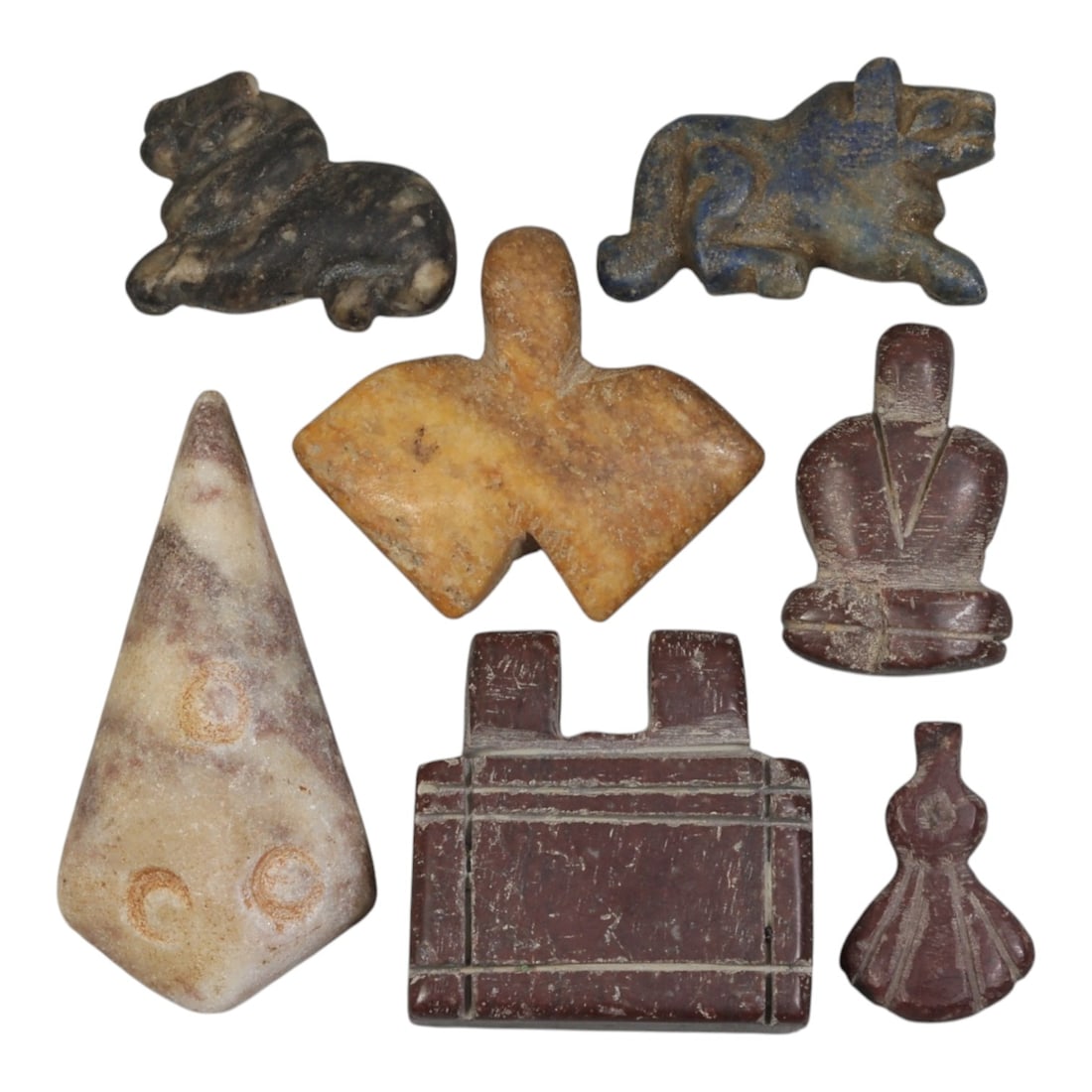 Lot of 7 Ancient Coptic Egyptian Multi-Stone Amulets, Circa Roman to Coptic Era, 91AH: Carved from diverse materials including speckled stone, lapis lazuli, yellowish marble, pinkish stone, and reddish-brown varieties, the group consists of seven distinct amulets, ranging in size from 2