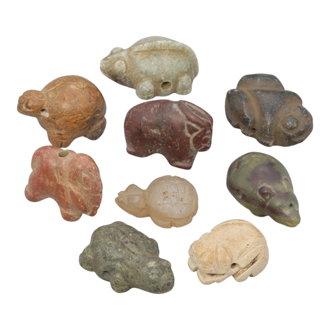 Lot of 9 Ancient Near Eastern Zoomorphic Stone Amulets, Circa Late Bronze to Iron Age, 61WT: Carved from various stones, including green, brown, red, and translucent varieties, the group consists of nine distinct zoomorphic amulets. The set includes stylized representations of animals such as
