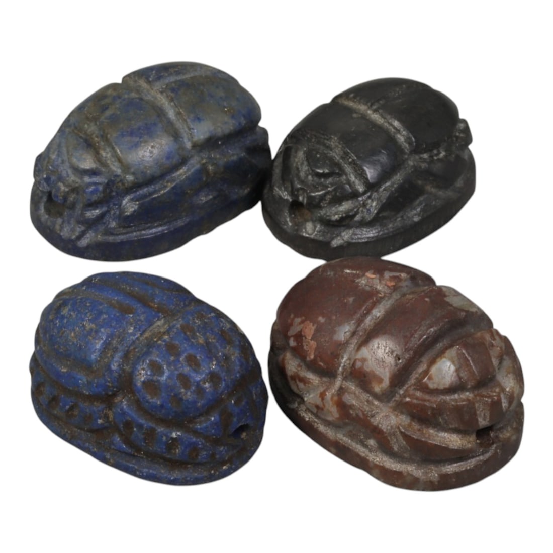 Lot of 4 Ancient Coptic Egyptian Multi-Stone Scarabs, Circa Roman to Coptic Era, 100WT: Carved from lapis lazuli, dark stone, and reddish-brown stone, the group consists of four distinct scarab amulets, each measuring approximately 2 cm (0.79 in.) in length. Each piece features the chara