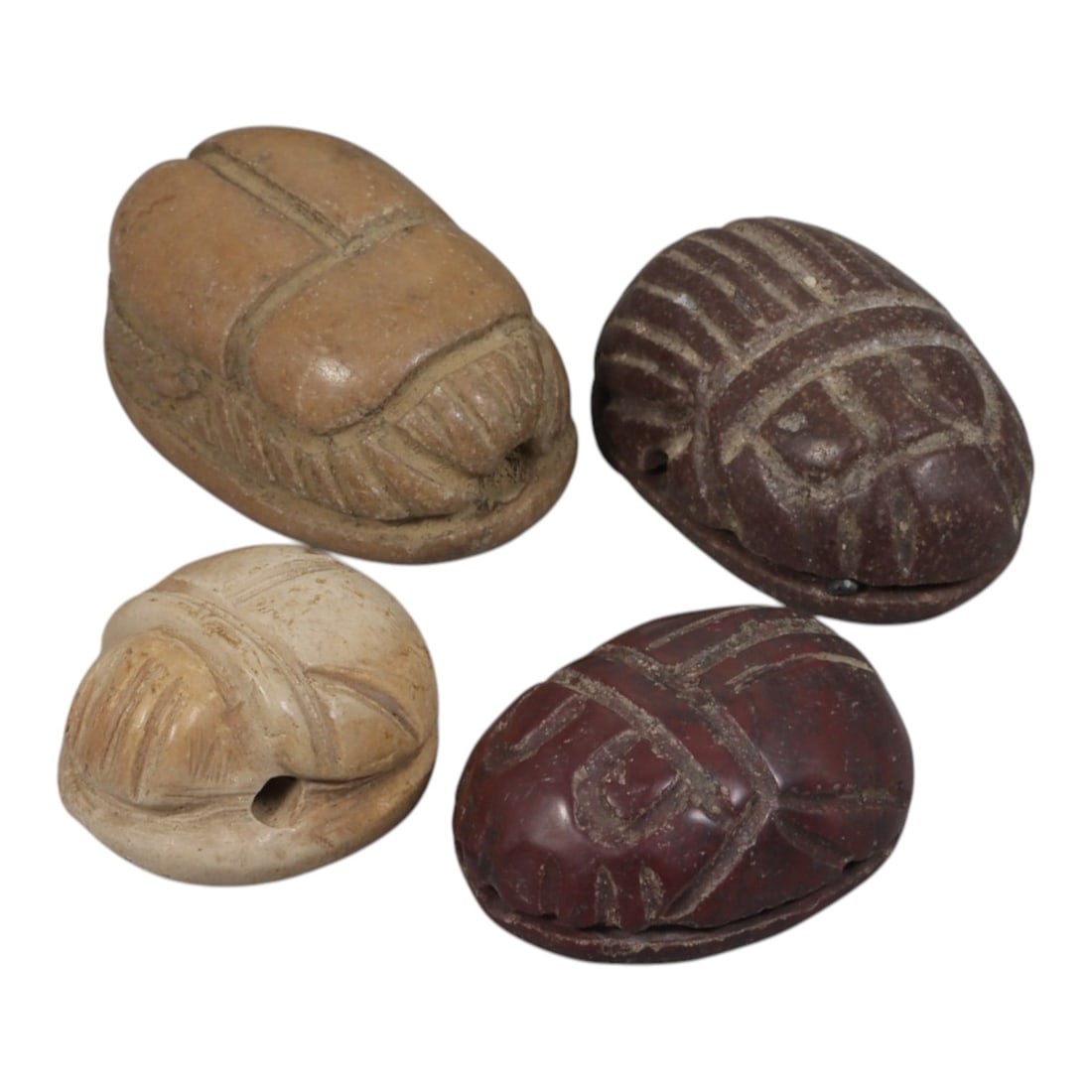 Lot of 4 Ancient Coptic Egyptian Multi-Stone Scarab Amulets, Circa Roman to Coptic Era, 84AH: Carved from a variety of earth-toned stones including light beige limestone, reddish-brown stone, and dark brown stone, the group consists of four distinct scarab amulets, ranging in size from 1.5 cm 