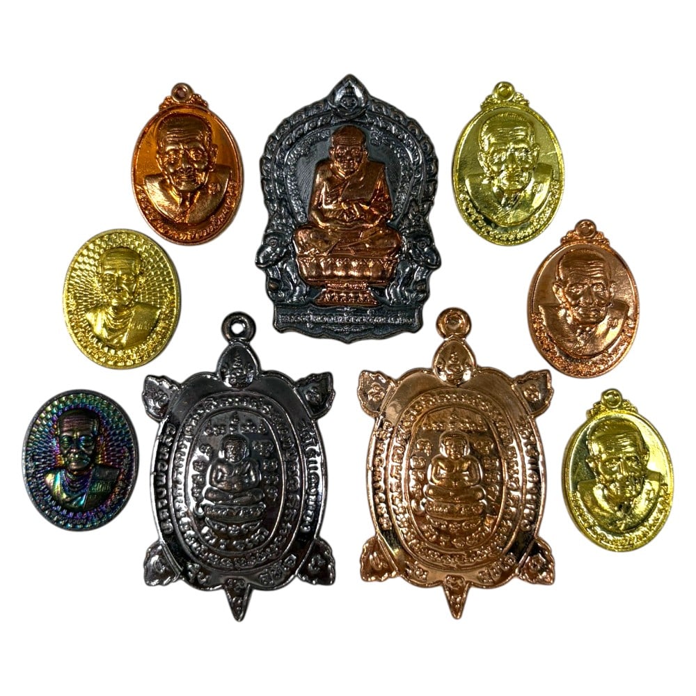 A Lot of 9 Vintage Thai Buddhist Amulets, Monk Medallions and Turtle Charms, 44AA: Comprising nine small pendants ranging from 2 to 4 cm in height. The collection features seven oval monastic portrait medallions in various metal finishes (gold, copper, blackened, and iridescent-tone