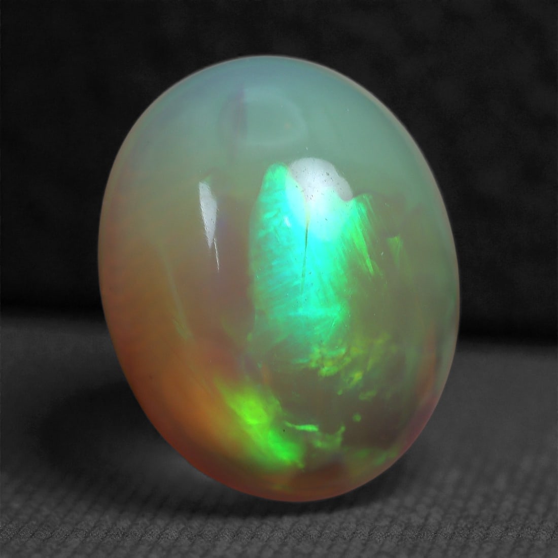 2.73 Carats Play-of-Color Welo Opal - Natural Ethiopian Gem 11x9mm, 20XC: This captivating Welo opal gleams with a luminous cascade of multi neon color that ripple across the stone's surface with every movement. The play-of-color is vivid and well-distributed, presenting a 