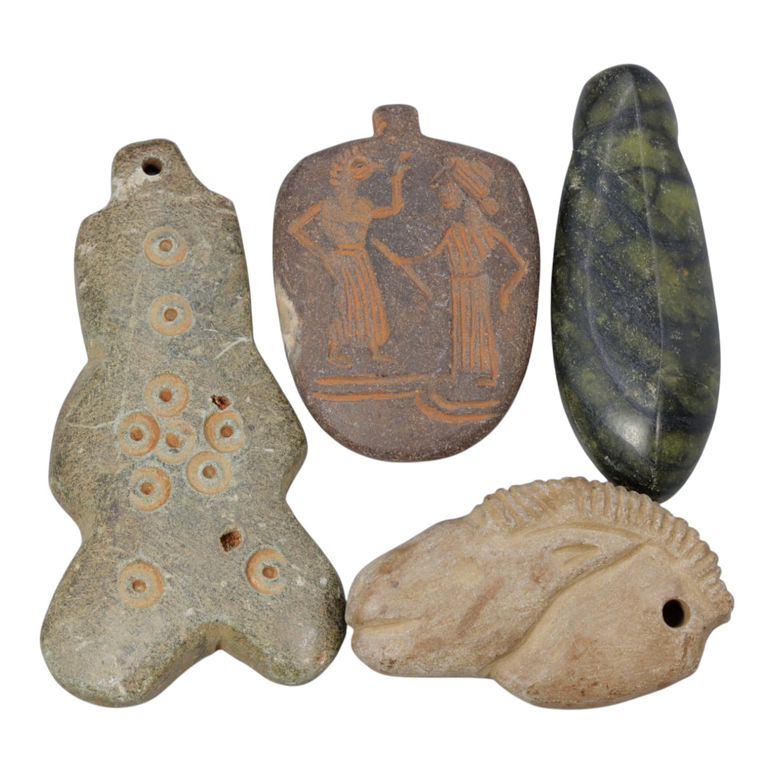 Lot of 4 Ancient Near Eastern Stone Amulets, 9WT: A collection of four ancient Near Eastern stone amulets, each carved from distinct materials and featuring varied symbolic designs. The set includes: a stylized humanoid pendant with drilled circle mo