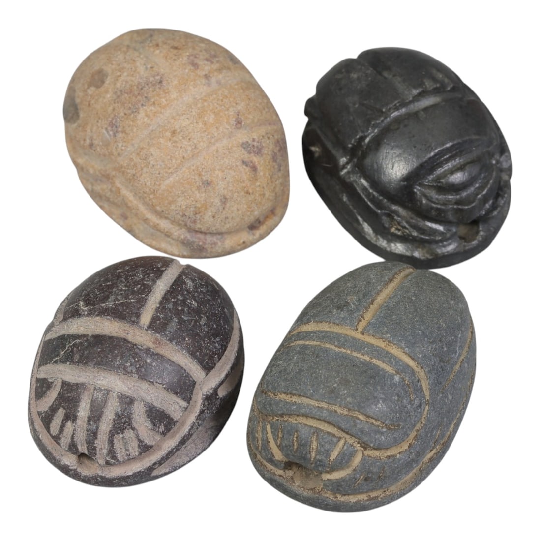 Lot of 4 Ancient Coptic Egyptian Stone Scarabs, Circa Roman to Coptic Era, 90AE: The group comprises four scarab amulets carved from stone in varying tones of light beige, black, dark brown, and grey. Each is rendered in the traditional scarab form, with incised lines defining the