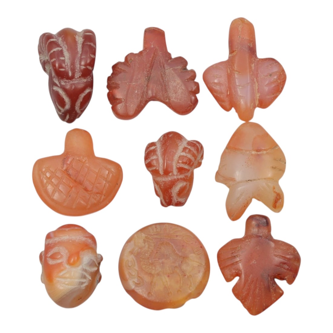Lot of 9 Ancient Coptic Egyptian Carnelian Amulets, Circa Roman to Coptic Era, 59WT: Carved from carnelian, exhibiting warm orange-red to reddish-brown tones with natural banding and translucency, the group consists of nine amulets of varying forms. The set includes zoomorphic motifs 