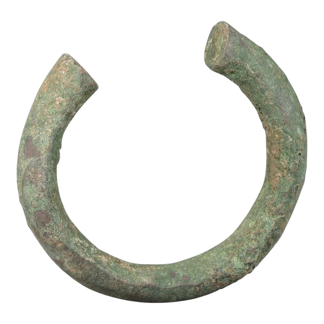 Ancient Roman Bronze Bracelet - Open Bangle Form, 34BN: Crafted from bronze, this open bracelet is formed as a thick, rounded rod creating a horseshoe-shaped cuff with a narrow gap between the flat terminals. The surface displays a heavily textured, uneven