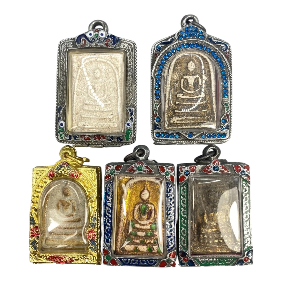 A Lot of 5 Vintage Thai Buddhist Amulets with Enamel and Jewel Accents, 15WT: A group of five vintage Thai Buddhist amulets, each encased in ornate metal frames with enamel detailing and jewel accents. The amulets feature traditional seated Buddha iconography, with varying fini