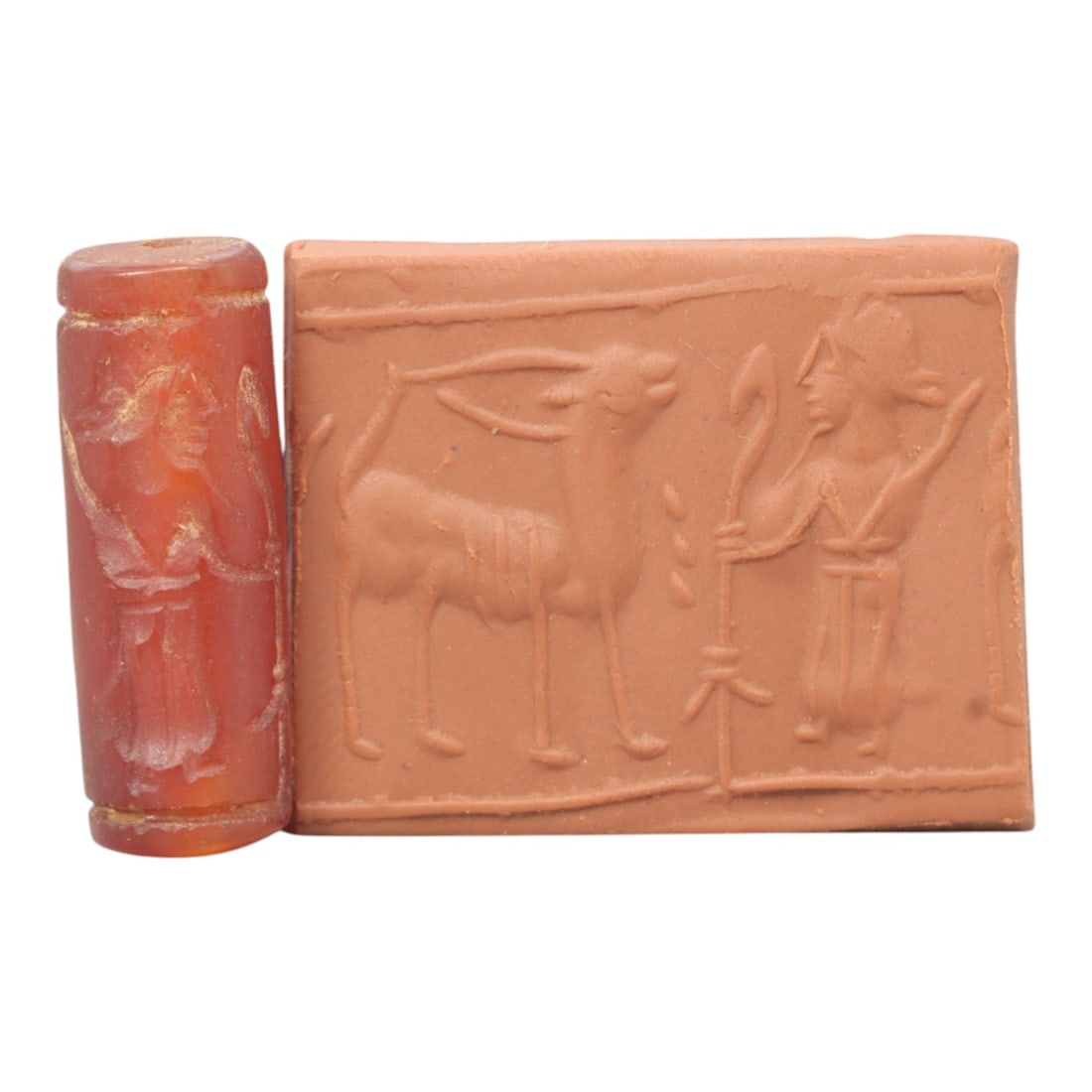 Ancient Carnelian Cylinder Seal - Mesopotamian Ibex & Winged Figure Scene, 71ZS: Carved from rich red carnelian, this ancient Mesopotamian cylinder seal features a refined linear relief composition of a standing ibex and a winged humanoid figure holding staffs, executed in the cha