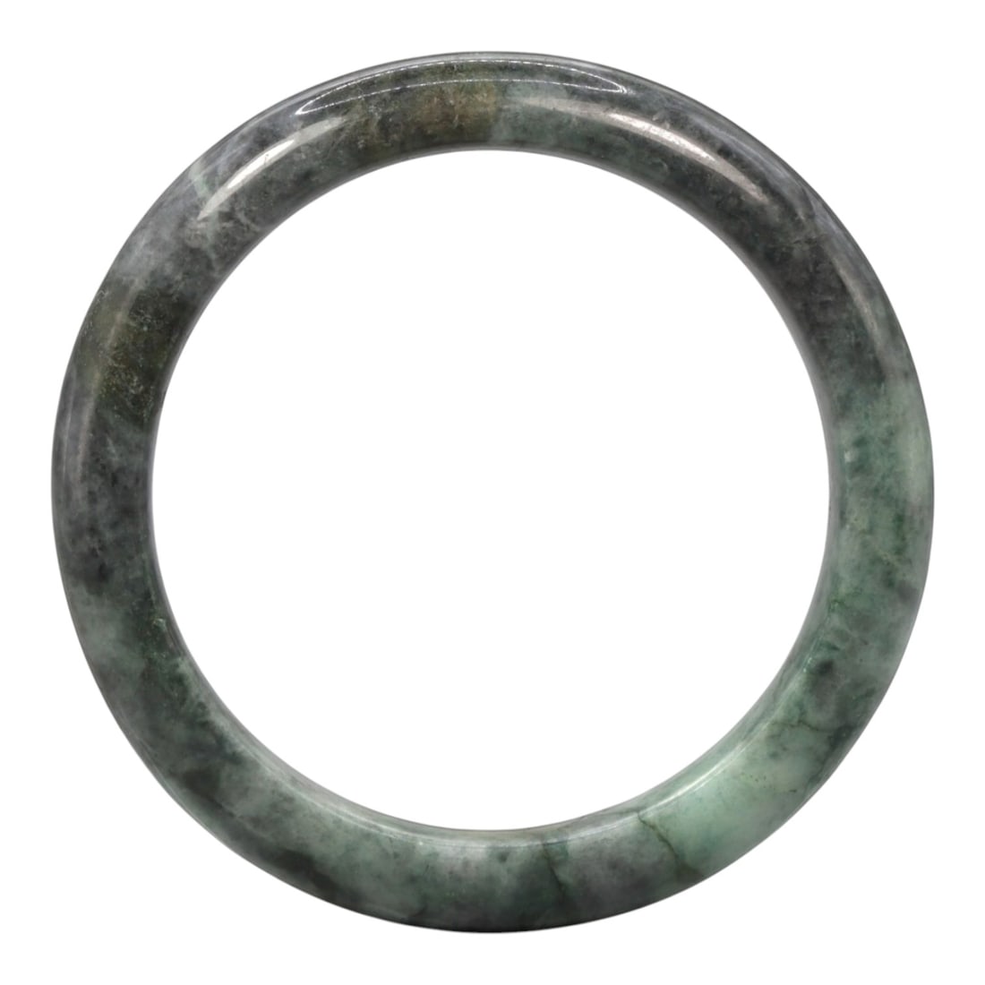 A Chinese Jadeite Jade Bangle Bracelet, 20th Century, 75ZK: Carved from jadeite jade with a variegated palette of pale green and deep greyish-black mottling throughout, the bangle is formed as a continuous circular band with a rounded cross-section. The surfac