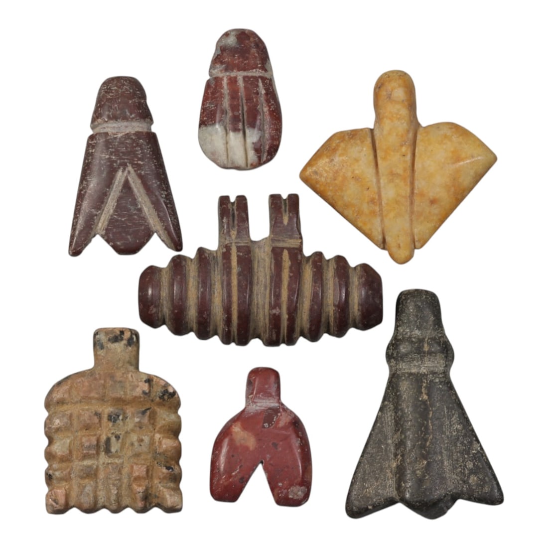 Lot of 7 Ancient Coptic Egyptian Multi-Stone Amulets, Circa Roman to Coptic Era, 100AH: Carved from various earth-toned stones including red marble, yellowish limestone, dark grey stone, and speckled varieties, the group consists of seven distinct amulets, ranging in size from 2 cm to 3.