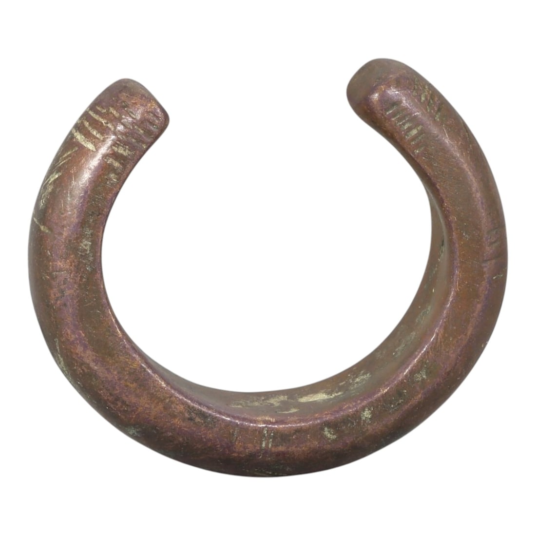Ancient Bronze Bracelet - Roman Decorated Bangle, 96BN: An open-form bracelet crafted from cast bronze, with a thick, rounded cross-section and incised linear decoration on both squared terminals. The simple geometric incisions reflect a common decorative 