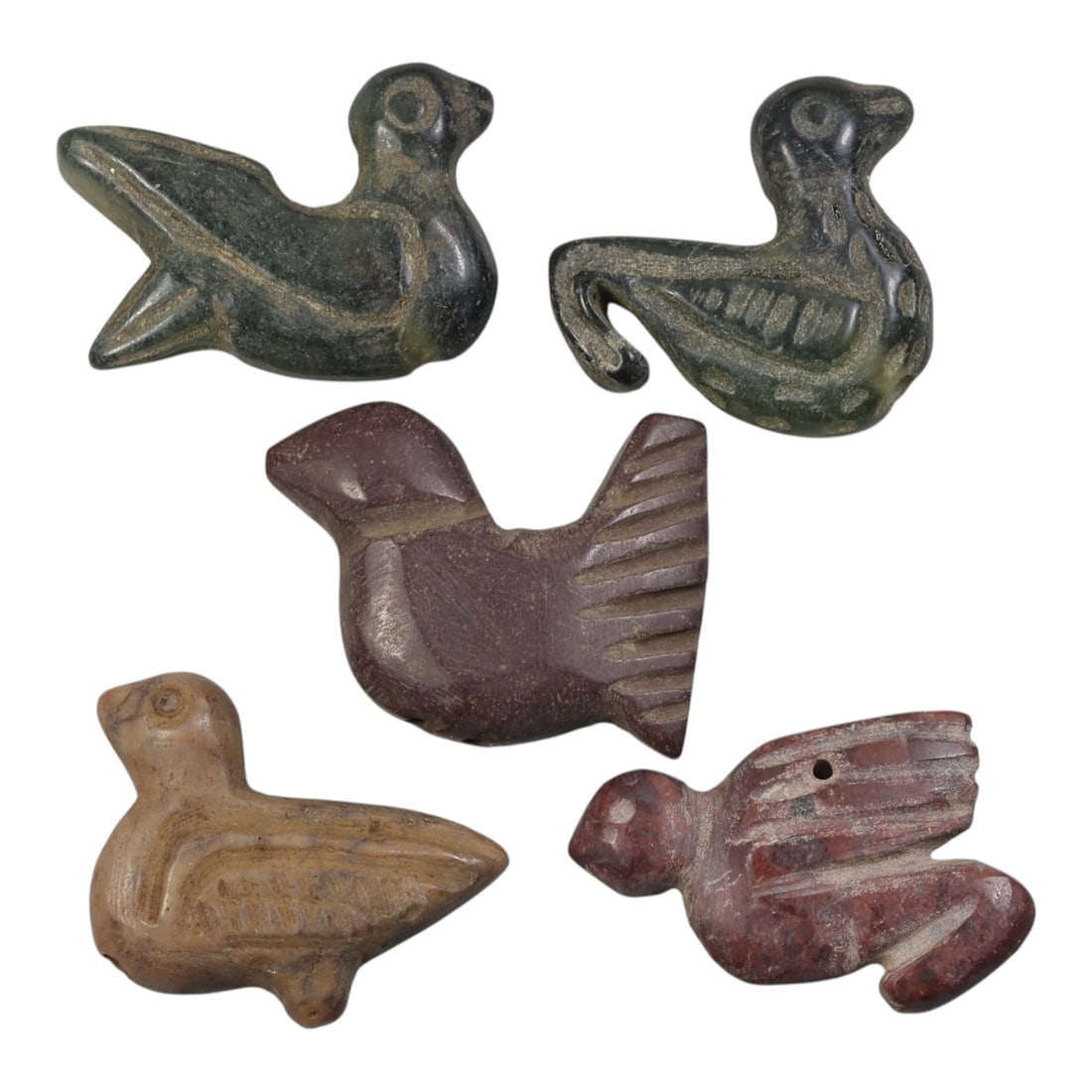 Lot of 5 Coptic Period Bird Amulets, Circa Late Antique/Early Medieval, 50AE: The group comprises five carved bird amulets characteristic of Coptic Egyptian art. The pieces are worked in varied stone tones: dark green, deep red-brown, light tan, and reddish stone, each exhibiti