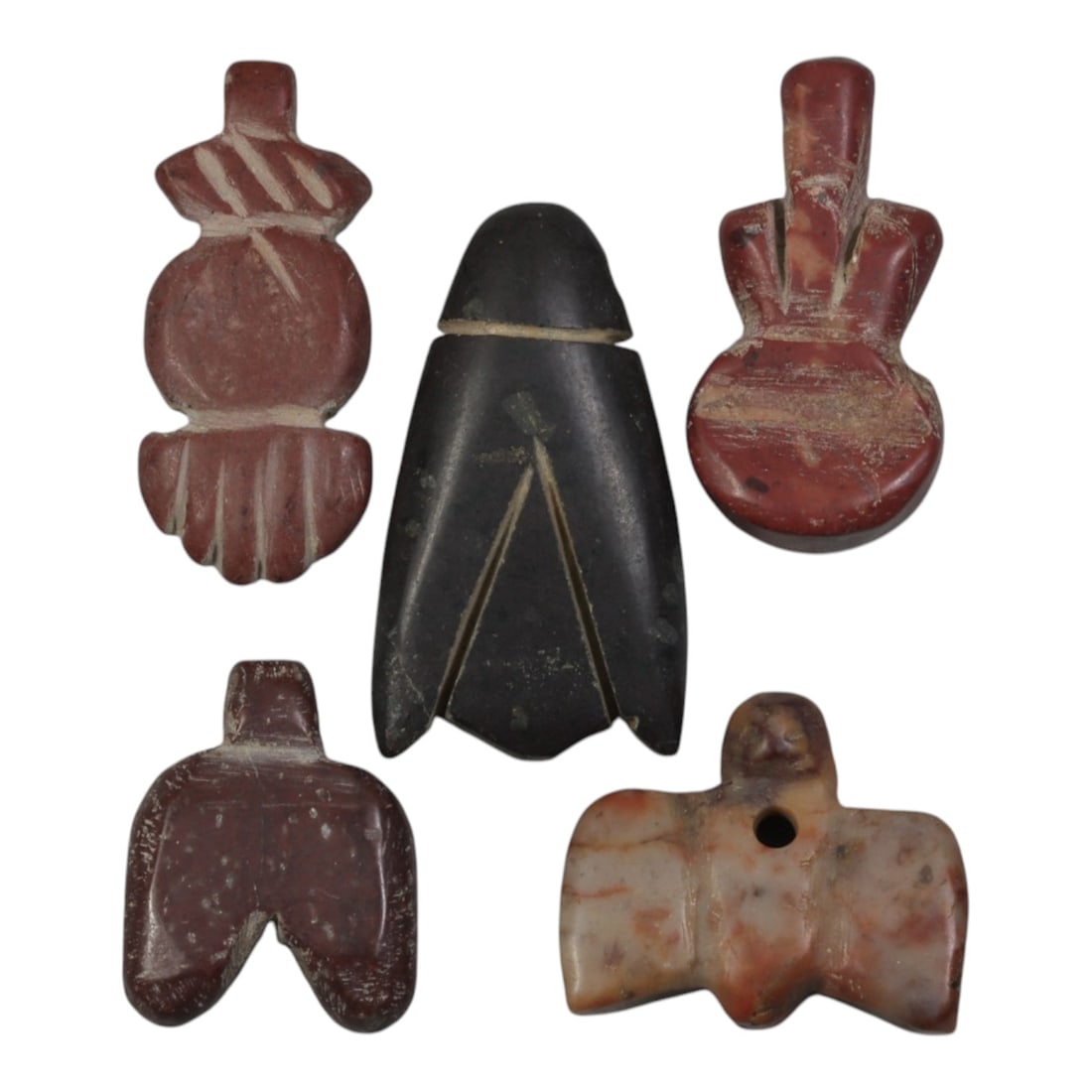 Lot of 5 Ancient Coptic Egyptian Stone Amulets, Circa Roman to Coptic Era, 84WP: Carved from various stones, including reddish-brown, black, and mottled pinkish varieties, the group consists of five amulets of distinct forms. The set includes stylized pendants: a hand-shaped form,