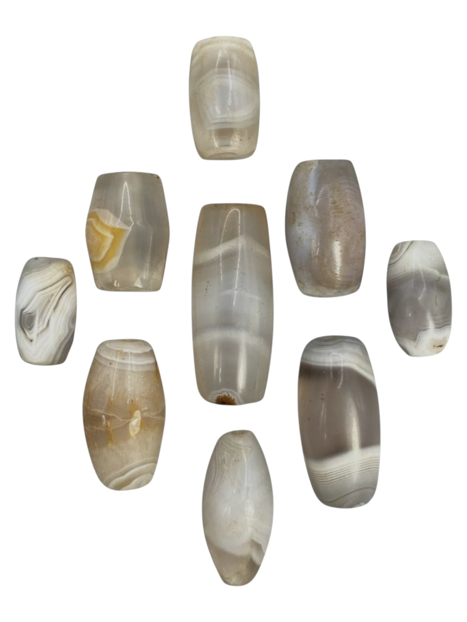 Lot of 9 Himalayan Banded Agate Beads, Ancient to Antique Period, 50WT: A group of nine beads crafted from banded agate, showcasing soft natural tones including translucent grey, milky white, and subtle amber hues, with characteristic concentric, wavy, and linear banding 