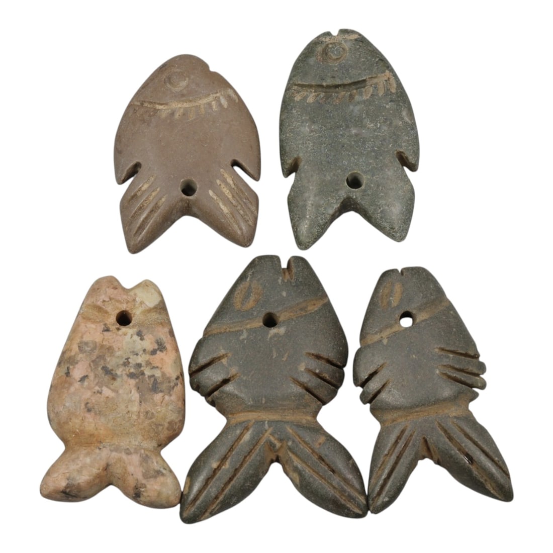 Lot of 5 Ancient Coptic Egyptian Stone Fish Amulets, Circa Roman to Coptic Era, 59WL: A collection of five stylized fish amulets carved from stone, characteristic of protective symbolism in Roman to Coptic period Egypt. Each amulet features a suspension hole for wear as a pendant. The 
