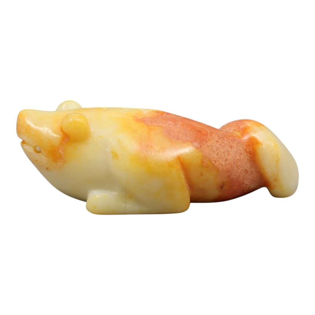 A Chinese Jade Frog Effigy, 20th Century, 41YC: The figure is carved from jade with creamy white coloration accented by areas of russet and ochre staining, the stone exhibiting natural mottling and translucency. It is worked as a recumbent frog sho