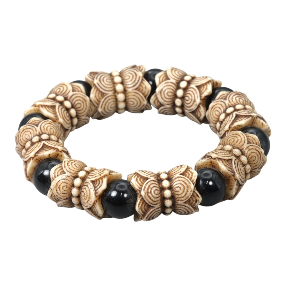 A Chinese Composite Bead Bracelet, 20th Century, 68FC: Composed of carved light-toned beads and contrasting dark spherical beads, the bracelet is assembled as a continuous strand forming a circular profile. The larger carved beads are worked with repeatin
