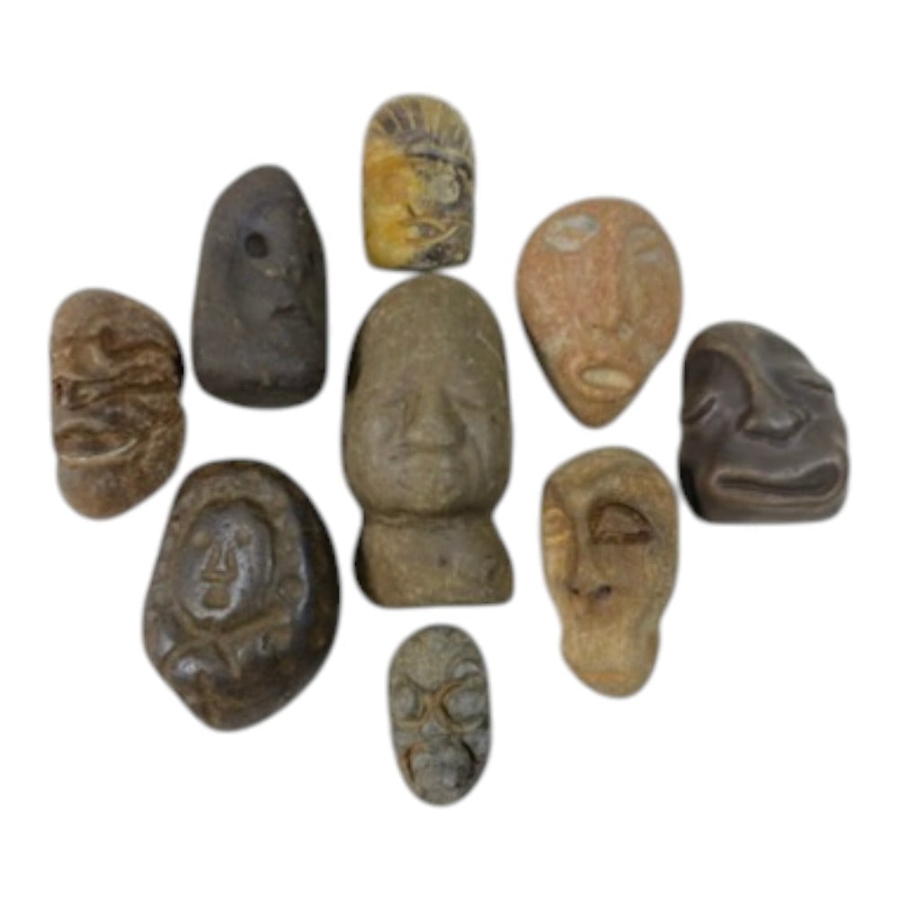 A Lot of 9 Ancient Medieval Stone Maskette and Head Amulets, 1AB: The group comprises nine carved stone amulets, including maskettes and stylized human heads. The pieces are rendered in varied styles, with some displaying deeply carved facial features and others wit