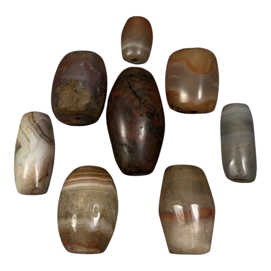 Lot of 8 Himalayan Banded Agate Beads, Ancient to Antique Period, 95AG: A group of eight beads crafted from banded agate, displaying natural tonal variations including translucent grey, brown, cream, and reddish hues, with characteristic concentric, linear, and wavy bandi