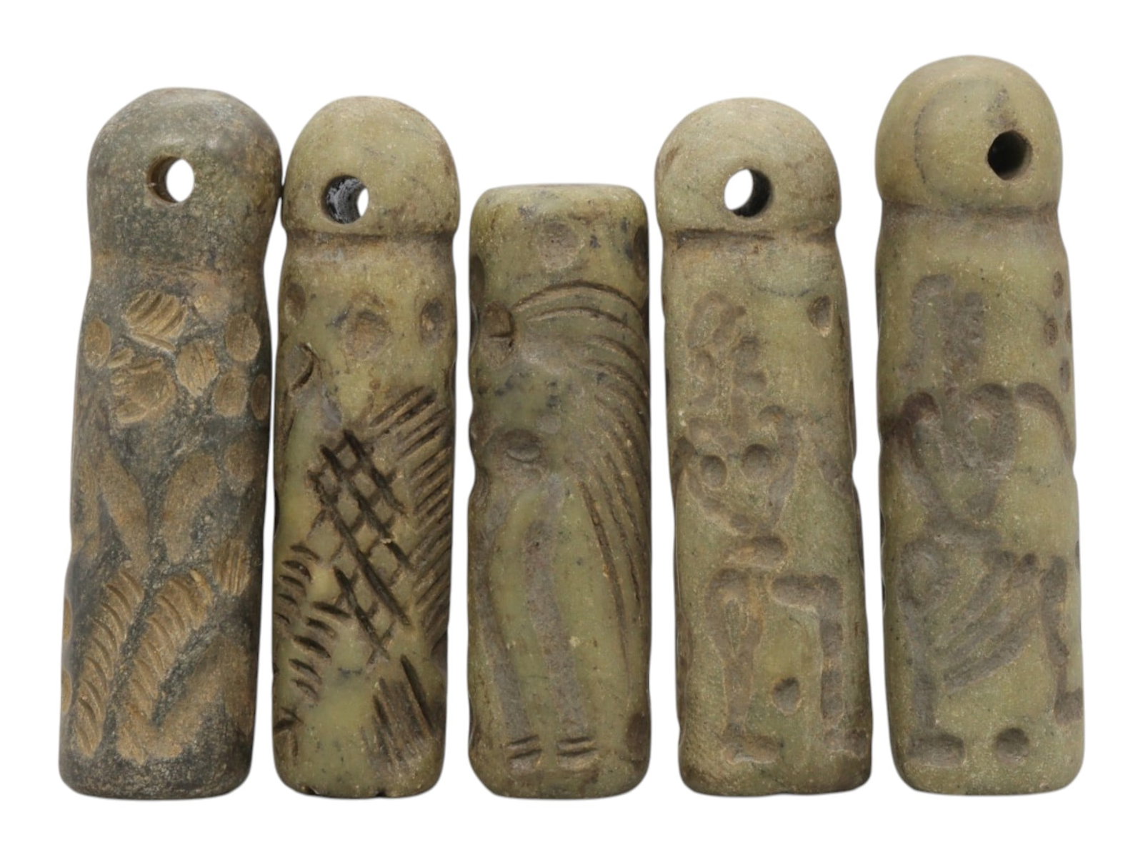 A Lot of 5 Ancient Mesopotamian Serpentine Cylinder Seals, 44WP: A curated lot of five ancient Mesopotamian-style cylinder seals, carved from serpentine stone with natural patination and wear consistent with age. Each seal features a cylindrical form, most with dom