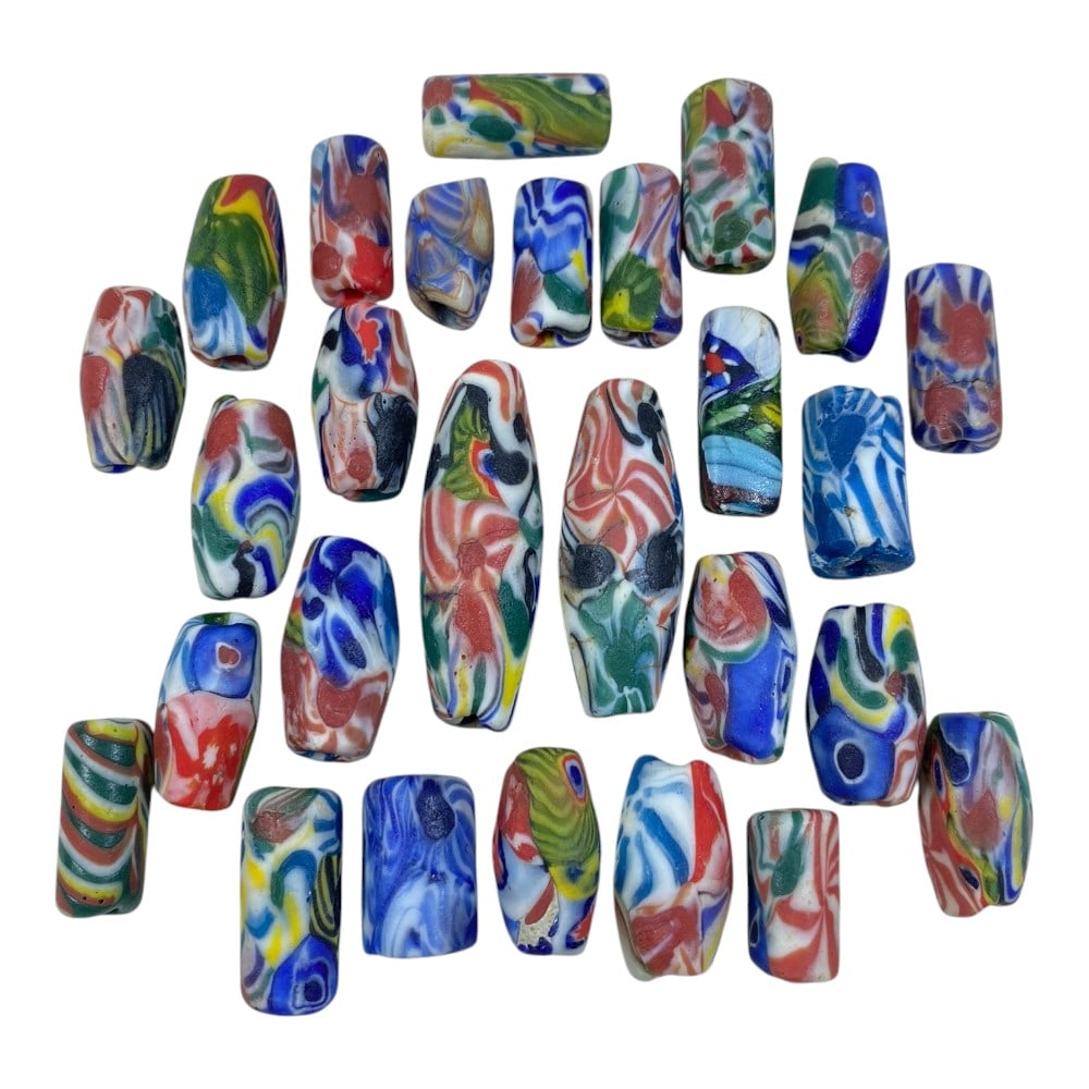 A Lot of 27 Vintage Mosaic Glass Beads, 86AA: The group comprises twenty-seven beads of cylindrical and elongated barrel shapes, crafted from polychrome mosaic glass. Each bead features unique swirling, marbled, and abstract patterns in vibrant c