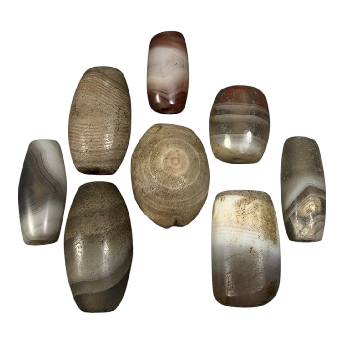Lot of 8 Himalayan Banded Agate Beads, Ancient to Antique Period, 12AH: A group of eight beads crafted from banded agate, exhibiting natural color variations including translucent grey, white, brown, and reddish tones, with characteristic concentric, wavy, and linear band