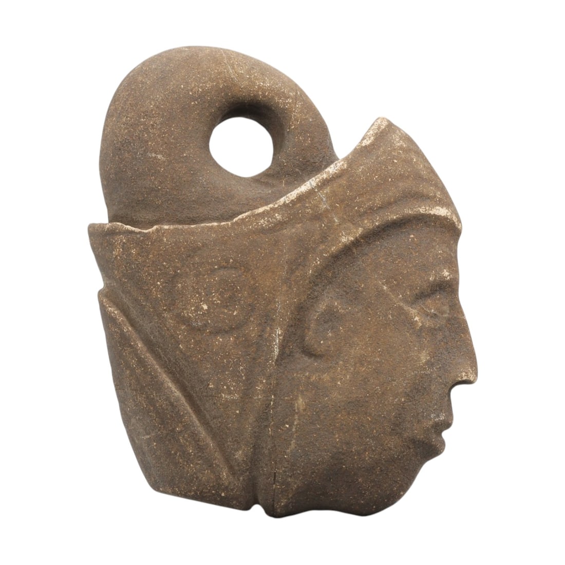 Ancient Tribal Stone Amulet - Anthropomorphic Head Pendant, 18WT: Carved stone pendant depicting a human head in profile, worked from a single piece of brown stone with natural patina and surface wear. The face features defined, incised eyes, nose, and mouth, with a