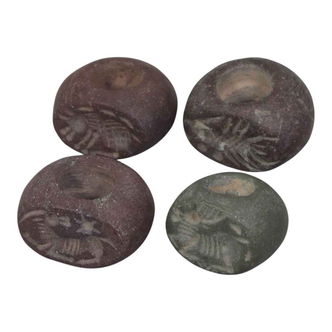 Lot of 4 Ancient Sasanian Stone Stamp Seals, Circa 3rd-7th Century CE, 73WP: A collection of four Sasanian period stamp seals, carved from varied dark and reddish stone types, each featuring a central drilled hole for suspension. The seals display characteristic Sasanian zoomo