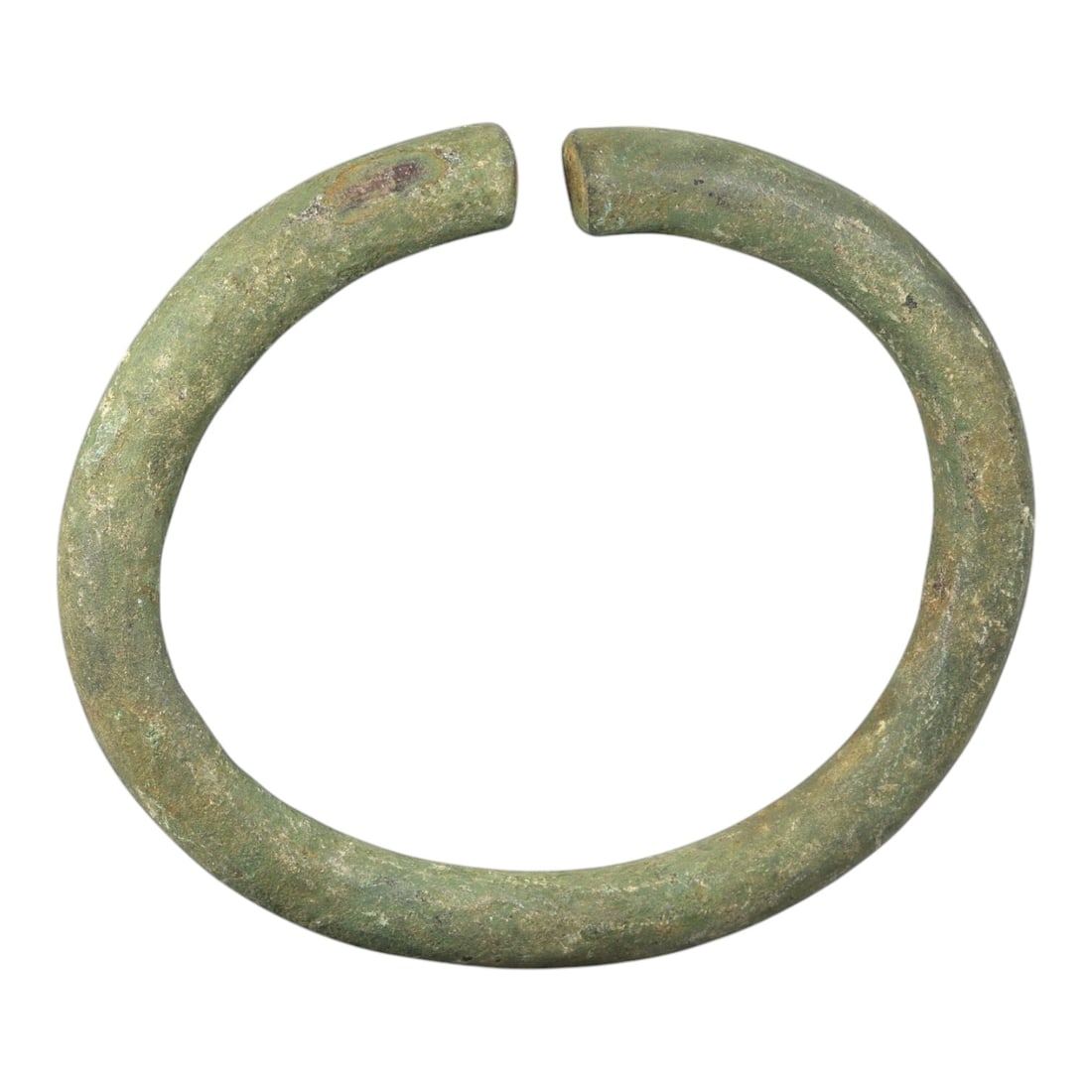 Ancient Roman Bronze Bracelet - Open Cuff Form, 35BN: Crafted from bronze, this open bracelet is formed as a thick, rounded rod creating a near-circular cuff with a narrow gap between the flat terminals. The surface displays a rich, uneven patina of gree
