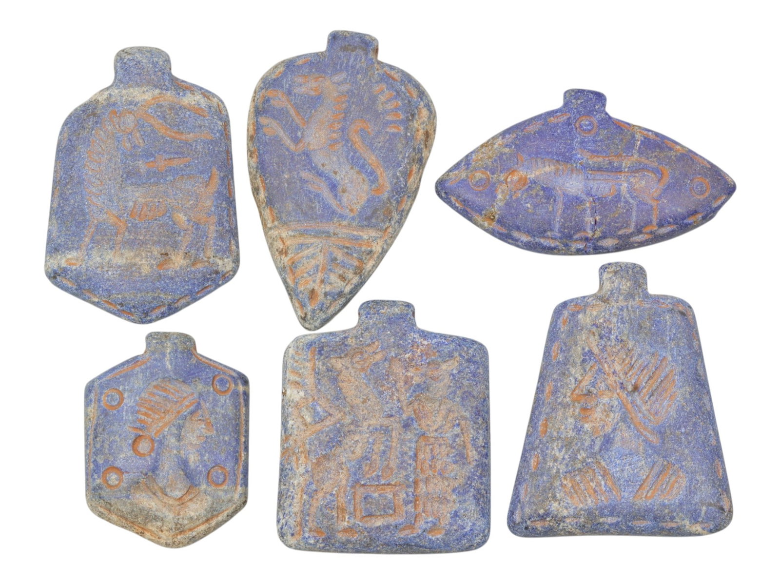 Lot of 6 Ancient Near Eastern Lapis Lazuli Amulets, Circa Late Bronze to Iron Age, 5WS: Carved from lapis lazuli, the group consists of six distinct amulets of varied forms. The set includes a shield-shaped pendant with a quadruped motif, a teardrop-shaped pendant with a leaping animal, 