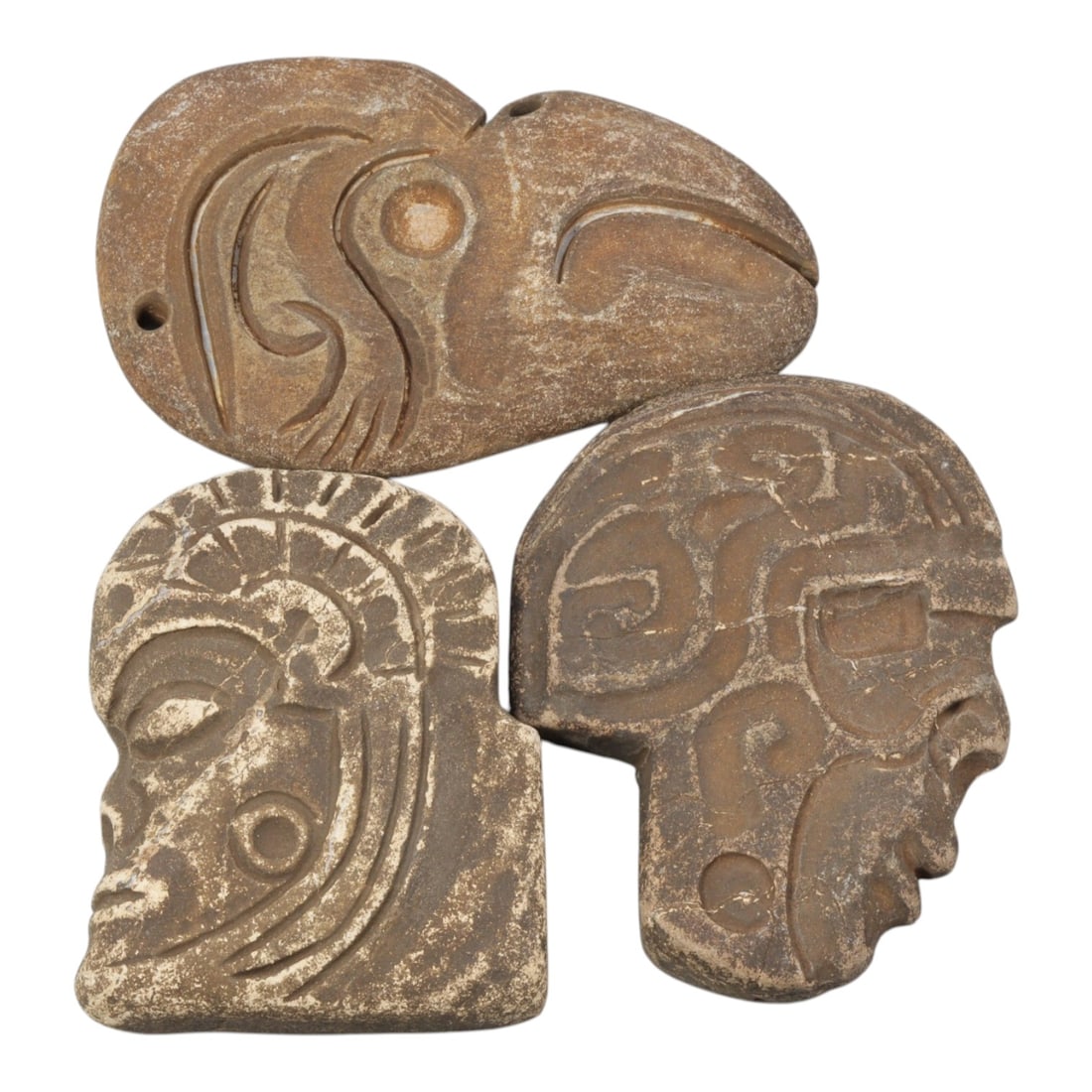 Lot of 3 Tribal Stone Carvings - Bird & Anthropomorphic Heads, 28WT: Three carved stone objects, comprising one zoomorphic bird head pendant and two anthropomorphic profile heads, all worked from brownish stone with visible patina and surface weathering. The bird head 