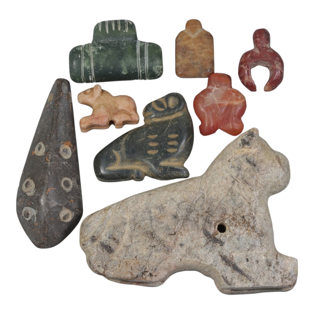 Lot of 8 Ancient Near Eastern Multi-Stone Amulets, 90AH: Carved from a diverse range of materials including green serpentine, brownish stone, red carnelian, pink marble, dark grey stone, and light grey stone, the group consists of eight distinct amulets, ra