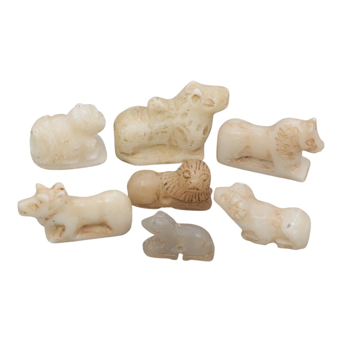 Lot of 7 Ancient Bactrian Zoomorphic Marble Amulets, Circa 3rd-2nd Millennium BCE, 55WT: Carved from marble and light-toned calcareous stone, the group consists of seven stylized zoomorphic amulets. Each piece is rendered in a reclining or standing form, depicting animals including lions,