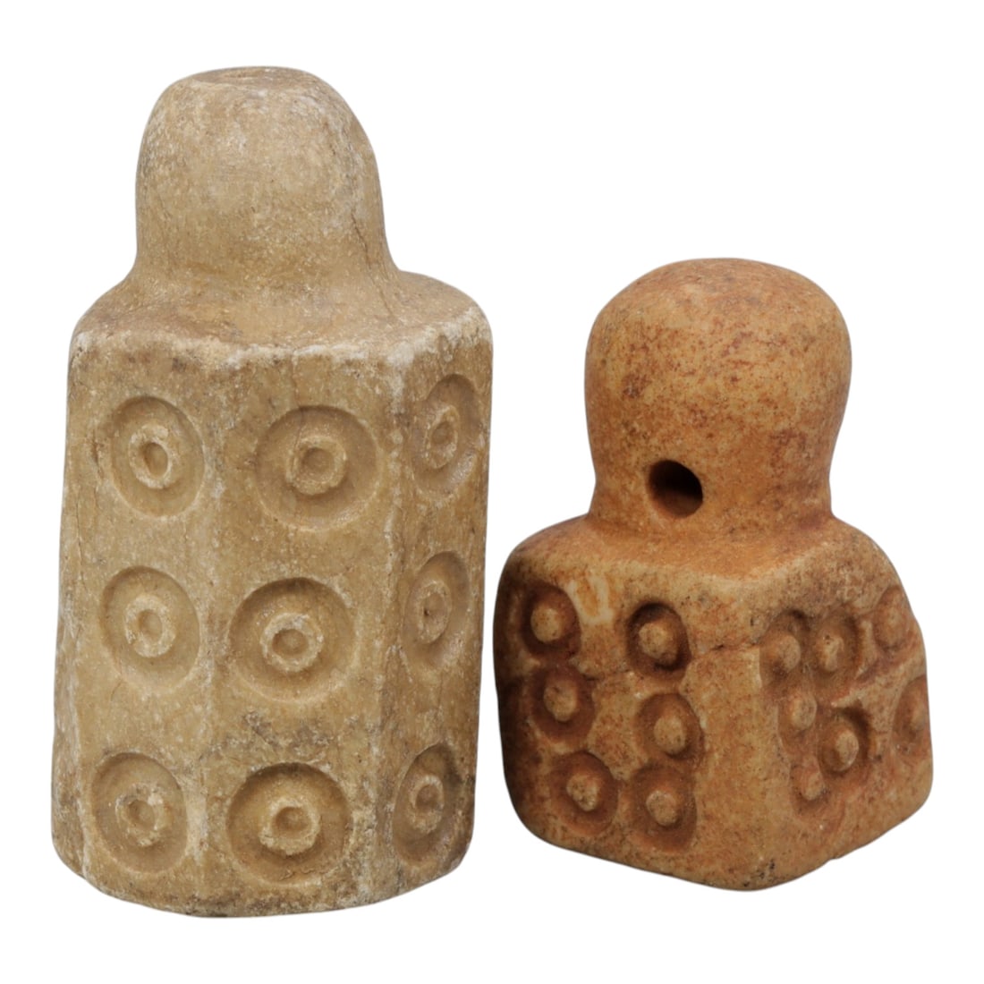 Lot of 2 Ancient Mesopotamian Stone Stamps Seals, 80WM: A collection of two ancient Mesopotamian stone stamps, carved from light-colored stone. The taller example features a cylindrical, faceted body with repeated incised circle motifs, while the shorter p