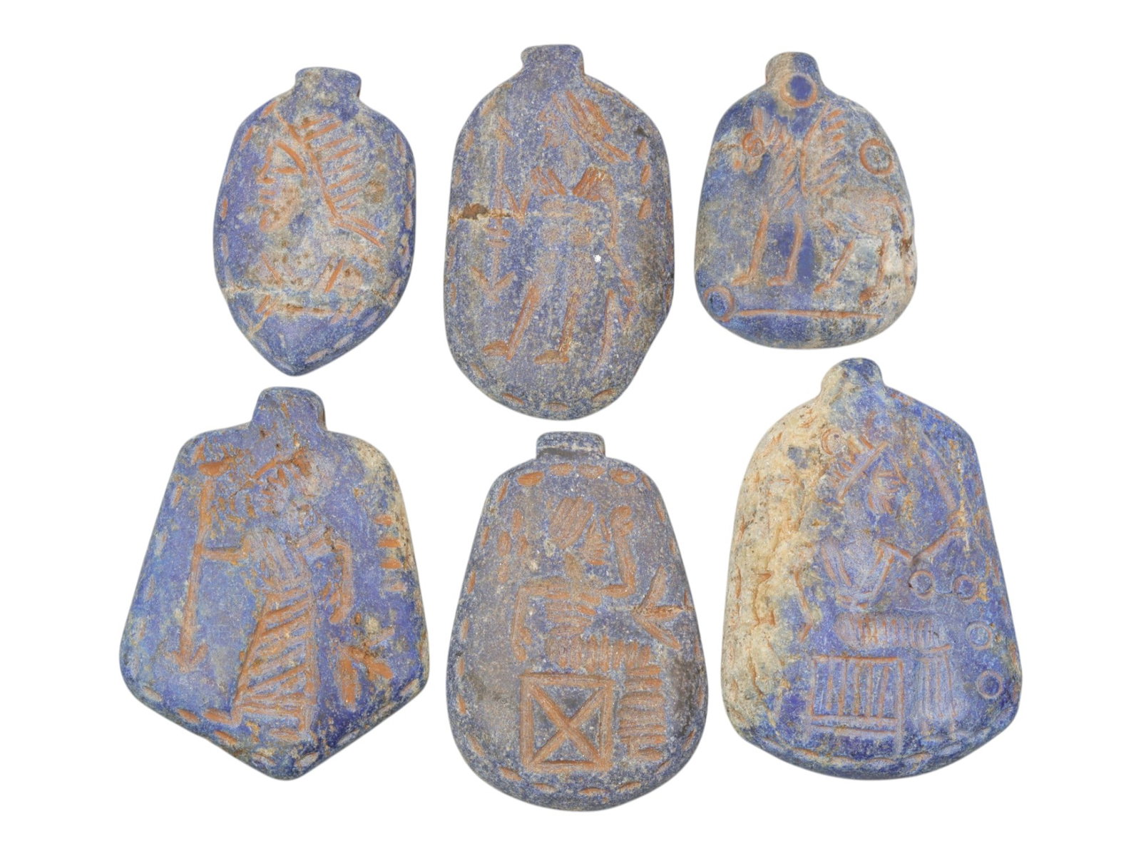 Lot of 6 Ancient Near Eastern Lapis Lazuli Amulets, Circa Late Bronze to Iron Age, 3WS: Carved from lapis lazuli, the group consists of six distinct amulets of varied forms. The set includes three pendants with human profile busts, one with a standing human figure holding a staff, one wi