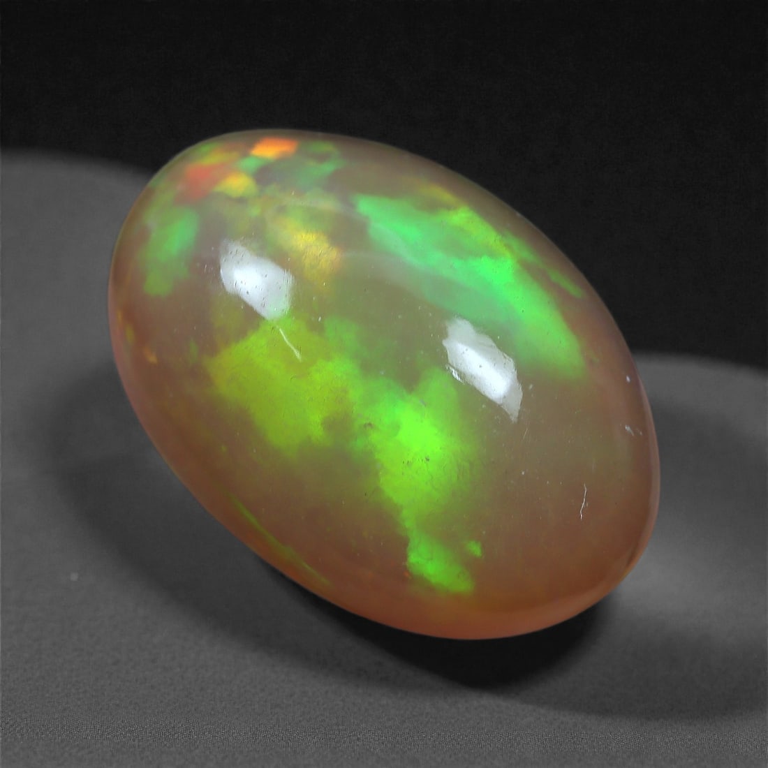 2.72 Carats Play-of-Color Welo Opal - Natural Ethiopian Gem 11x8mm, 30XC: This captivating Welo opal gleams with a luminous cascade of multi neon color that ripple across the stone's surface with every movement. The play-of-color is vivid and well-distributed, presenting a 
