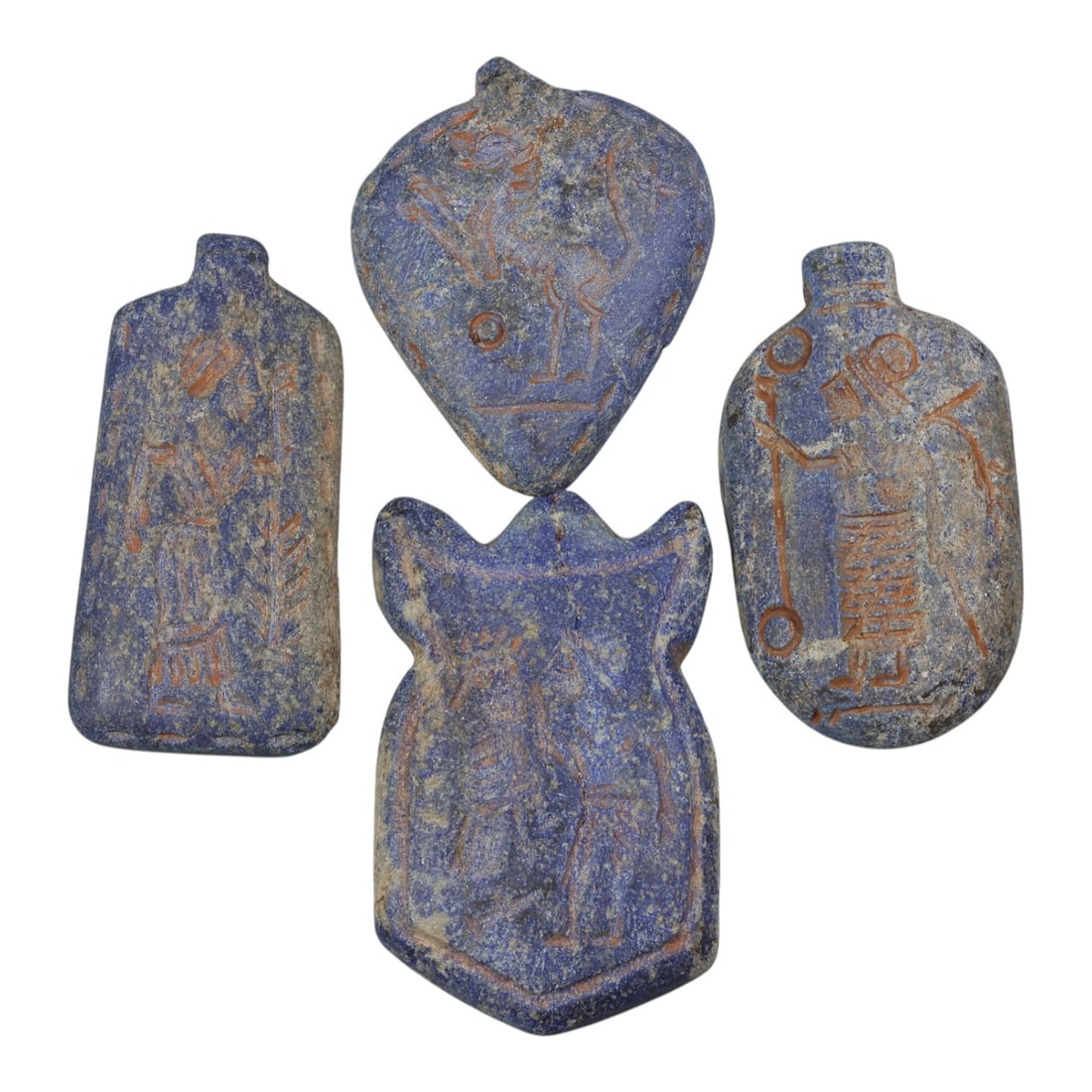 Lot of 4 Ancient Near Eastern Lapis Lazuli Amulets, 56WP: A collection of four hand-carved lapis lazuli amulets, attributed to the ancient Near Eastern cultures (likely Mesopotamian or related traditions). Each pendant features a deep blue lapis lazuli base 