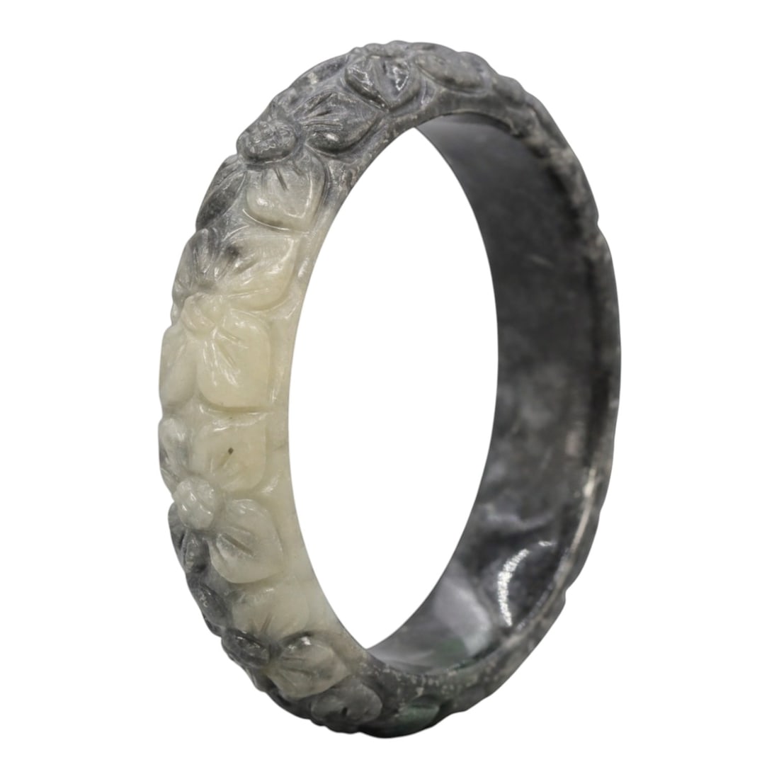 A Chinese Carved Jadeite Jade Bangle Bracelet, 20th Century, 47ZL: A fine jadeite bangle of flattened circular form, masterfully carved in relief with a continuous band of floral blossoms and scrolling foliate motifs. The stone exhibits a striking variegated palette,