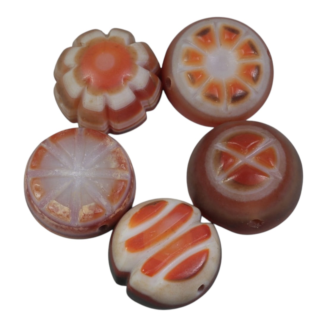 Lot of 5 Antique Himalayan Carnelian Beads, 51WP: A collection of five antique Himalayan carnelian beads, each intricately carved from banded carnelian stone. The beads feature distinct geometric and floral patterns, including sunburst, cross, and st