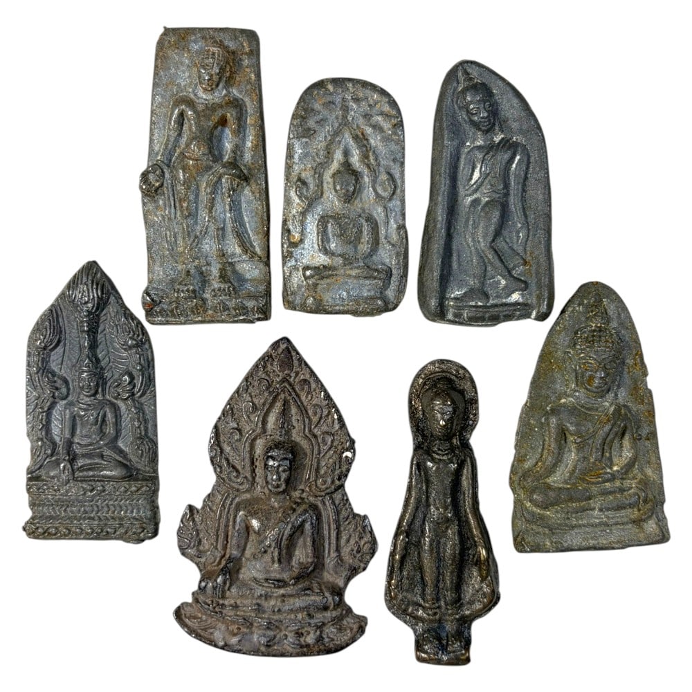 A Lot of 7 Vintage Southeast Asian Metal Buddha Amulets, 45AA: Comprising seven unmounted metal amulets ranging from 5.5 to 7 cm in height. Each piece is cast from lead or base metal, depicting Buddha in both seated and standing forms, with varied stylistic backg