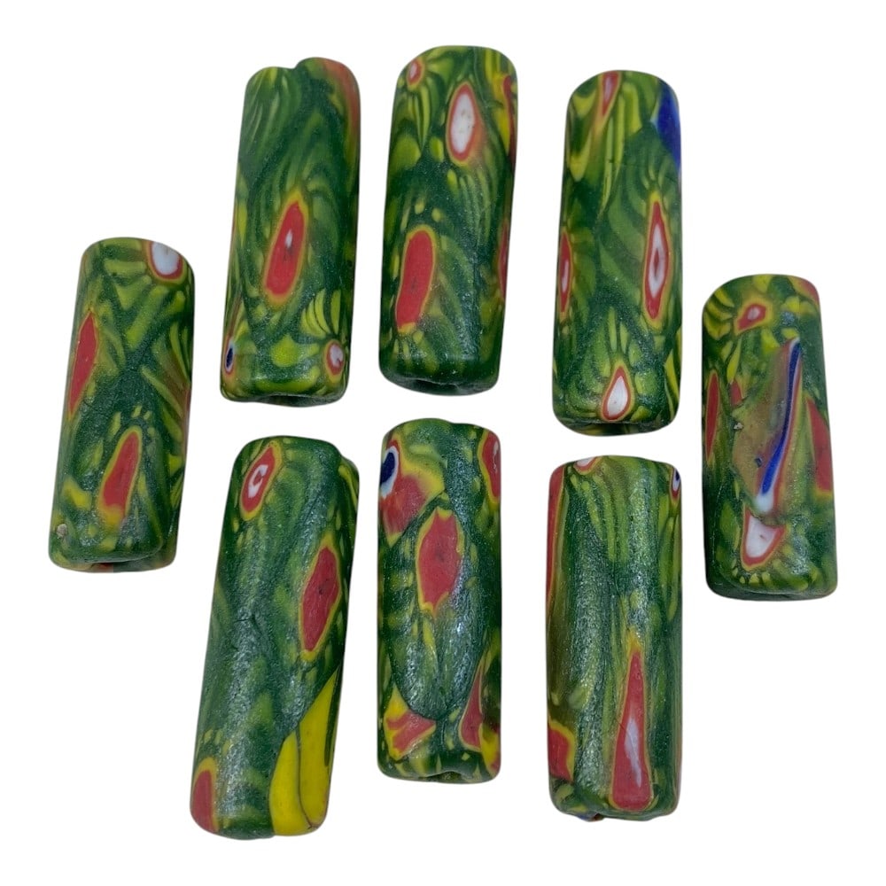 A Lot of 8 Vintage Cylindrical Millefiori Glass Trade Beads, 82AA: This collection features 8 striking cylindrical glass beads, characteristic of vintage trade bead craftsmanship. Crafted using the millefiori technique, each bead has a rich green base, overlaid with 