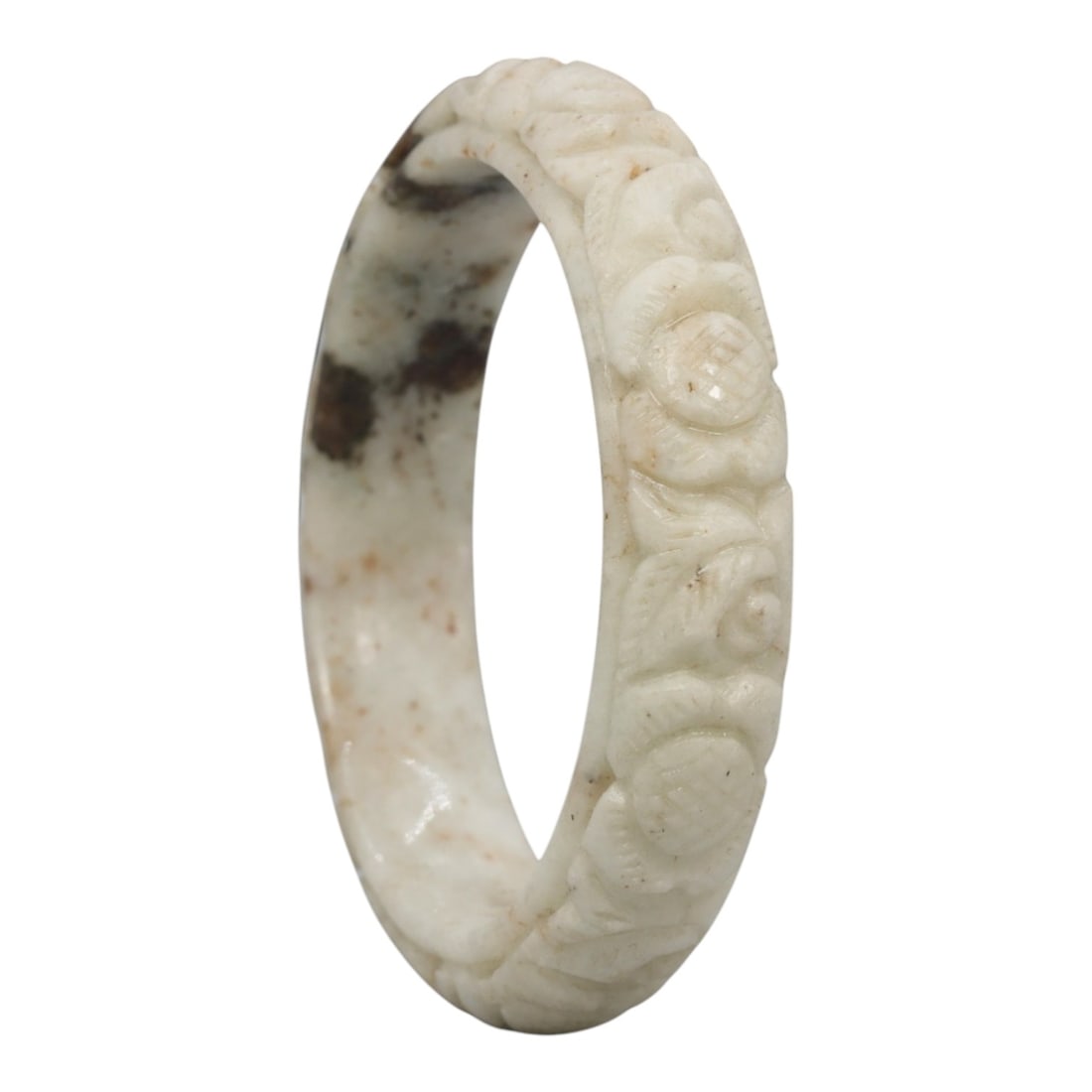 A Chinese Carved Jadeite Jade Bangle Bracelet, 20th Century, 20ZL: A fine jadeite bangle of flattened circular form, masterfully carved in relief with a continuous band of floral blossoms and scrolling foliate motifs. The stone exhibits a creamy white base, heavily a