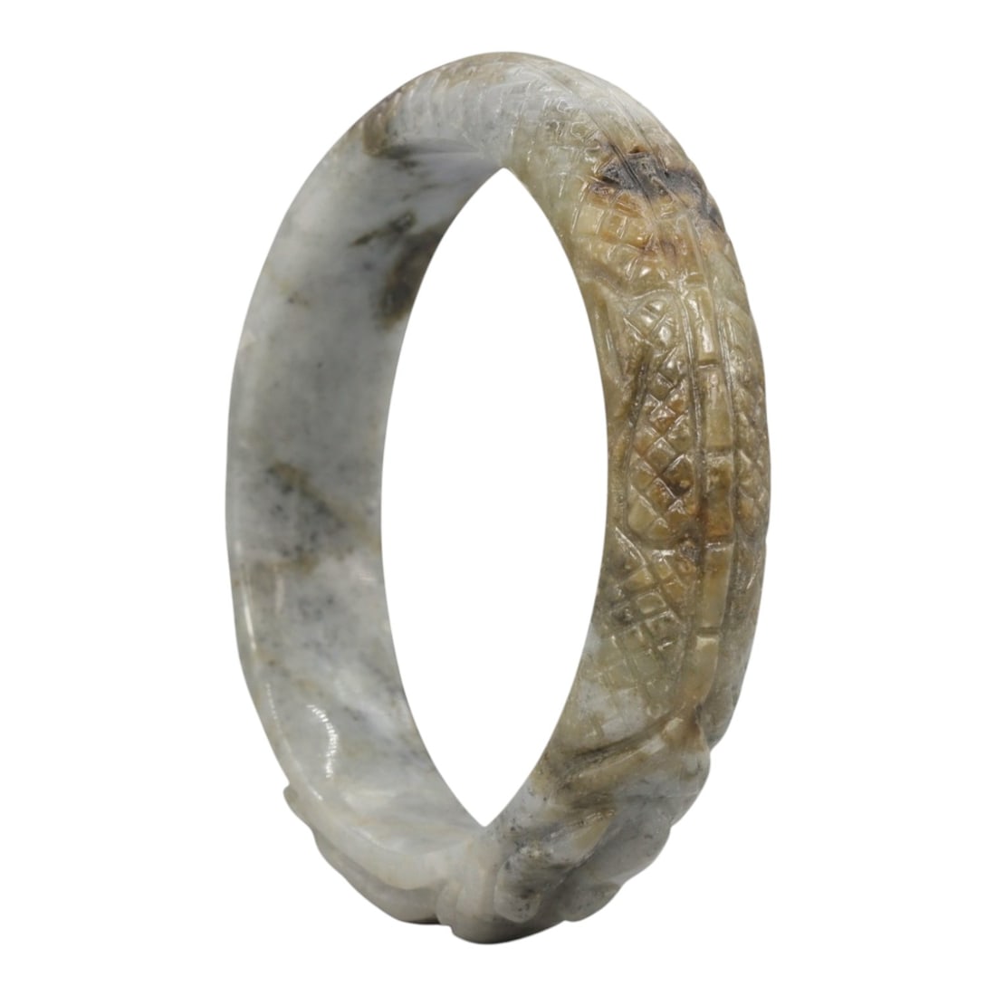 A Chinese Carved Jadeite Jade Bangle Bracelet, 20th Century, 30ZL: A fine jadeite bangle of circular form, masterfully carved in relief with a continuous band of a sinuous dragon coiling around its circumference. The stone exhibits a striking variegated palette, with